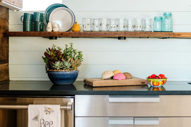 Inspiration for an industrial single-wall kitchen remodel in Austin with stainless steel cabinets and blue backsplash