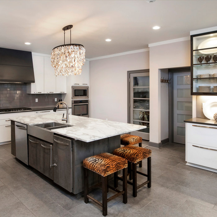 Example of a large u-shaped gray floor kitchen design with a farmhouse sink, flat-panel cabinets, white cabinets, gray backsplash, subway tile backsplash, stainless steel appliances, an island and gra