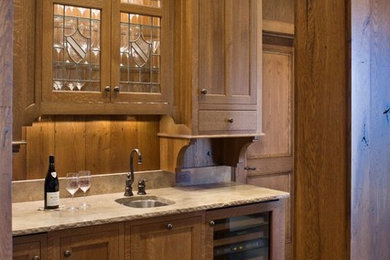 Example of a mid-sized mountain style single-wall medium tone wood floor and brown floor wet bar design in Charlotte with an undermount sink, shaker cabinets, medium tone wood cabinets and wood backsplash