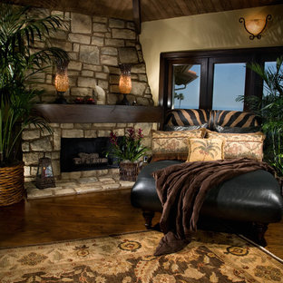 Ejemplo de salón para visitas cerrado, mediterráneo, grande, con paredes beige, suelo de madera en tonos medios, chimenea de esquina, marco de chimenea de piedra y suelo marrón