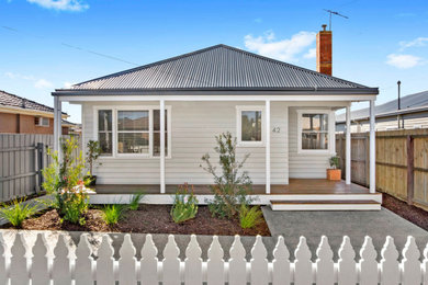 This is an example of a mid-sized contemporary one-storey beige house exterior in Geelong with wood siding, a gable roof and a metal roof.