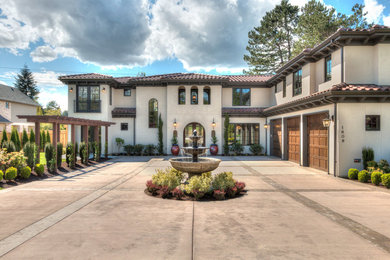 Large mediterranean beige two-story stone house exterior idea in Seattle with a hip roof and a tile roof
