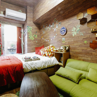 Immagine di una camera matrimoniale etnica con pavimento in compensato e nessun camino