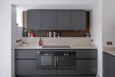 Photo of a medium sized contemporary l-shaped kitchen/diner in West Midlands with flat-panel cabinets.