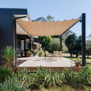 ウロンゴンの大きいミッドセンチュリースタイルのおしゃれな裏庭のデッキ (オーニング・日よけ) の写真