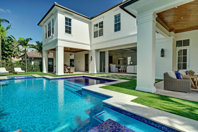 Large beach style backyard concrete paver and custom-shaped lap pool photo in Miami