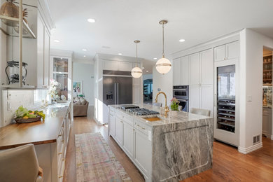 Example of a large transitional u-shaped medium tone wood floor eat-in kitchen design in Denver with flat-panel cabinets, gray cabinets, an island, stainless steel appliances, an undermount sink, white backsplash and ceramic backsplash