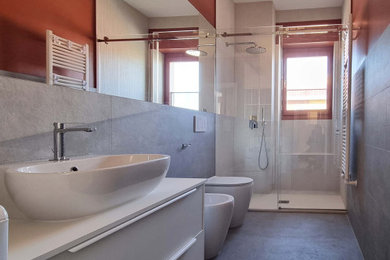 Ispirazione per una stanza da bagno con doccia minimal di medie dimensioni con ante bianche, WC a due pezzi, piastrelle grigie, piastrelle in gres porcellanato, pavimento in gres porcellanato, lavabo a bacinella, top in superficie solida, pavimento grigio, top bianco, panca da doccia, un lavabo, mobile bagno sospeso e porta doccia scorrevole