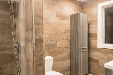 Mittelgroßes Modernes Badezimmer En Suite mit flächenbündigen Schrankfronten, beigen Schränken, Duschnische, braunen Fliesen, Porzellanfliesen, Porzellan-Bodenfliesen, braunem Boden, Schiebetür-Duschabtrennung und weißer Waschtischplatte in Montreal