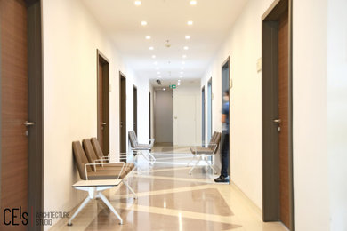 Ejemplo de recibidores y pasillos minimalistas de tamaño medio con paredes blancas, suelo vinílico, suelo beige y panelado