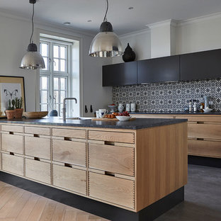 Свежая идея для дизайна: кухня в скандинавском стиле с плоскими фасадами, черными фасадами, разноцветным фартуком и бетонным полом - отличное фото интерьера