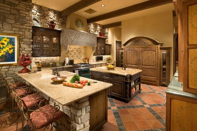 Inspiration for a large mediterranean u-shaped terra-cotta tile and multicolored floor kitchen remodel in Phoenix with a drop-in sink, glass-front cabinets, dark wood cabinets, granite countertops, stainless steel appliances and an island
