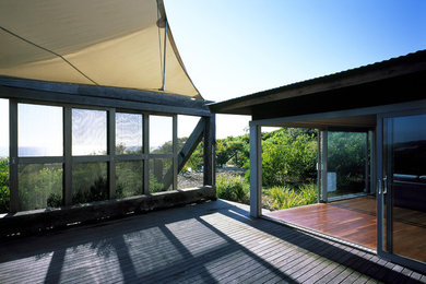 Inspiration for an expansive beach style backyard deck in Wollongong with an awning.
