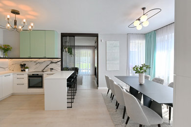 Example of a minimalist kitchen design in Other with flat-panel cabinets, turquoise cabinets, laminate countertops, ceramic backsplash, black appliances and a peninsula