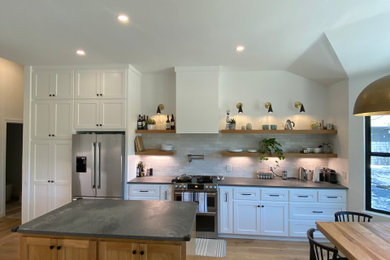Inspiration for a large contemporary light wood floor kitchen remodel in Austin with shaker cabinets, white cabinets, quartzite countertops, ceramic backsplash, stainless steel appliances, an island and gray countertops
