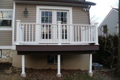 Inspiration for a mid-sized back porch remodel in New York with decking and an awning