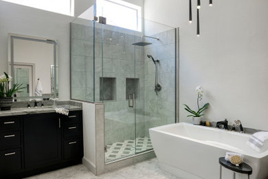 Large transitional master gray tile and porcelain tile porcelain tile, multicolored floor and single-sink bathroom photo in Phoenix with shaker cabinets, black cabinets, white walls, an undermount sink, quartzite countertops, a hinged shower door, gray countertops and a freestanding vanity