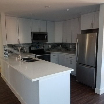 Compact White Kitchen with Peninsula and Mosaic Backsplash