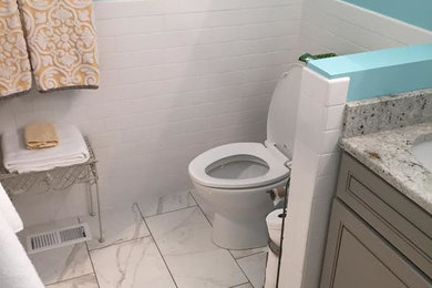 Inspiration for a mid-sized transitional 3/4 white tile and subway tile porcelain tile and white floor bathroom remodel in Salt Lake City with recessed-panel cabinets, beige cabinets, a two-piece toilet, blue walls, an undermount sink and granite countertops