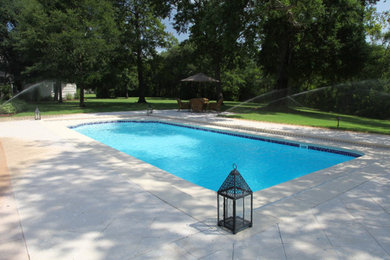 Photo of a mid-sized traditional backyard rectangular lap pool in Other with concrete pavers.