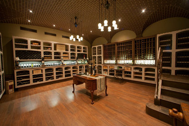 This is an example of an arts and crafts wine cellar in San Francisco with storage racks, medium hardwood floors and orange floor.