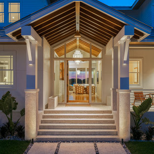 タンパの大きい片開きドアトランジショナルスタイルのおしゃれな玄関ラウンジ (白い壁、テラゾーの床、木目調のドア、マルチカラーの床) の写真