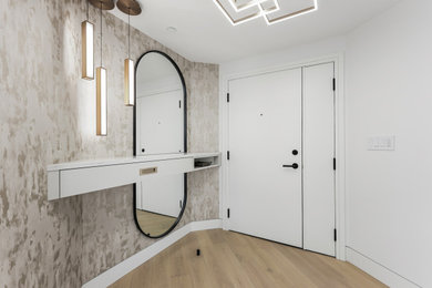 Large trendy light wood floor, brown floor and wallpaper entryway photo in Calgary with white walls and a white front door