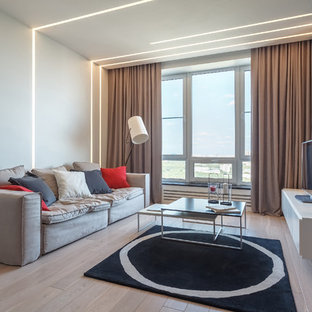 Inspiration för ett mellanstort funkis allrum med öppen planlösning, med vita väggar, laminatgolv, en fristående TV och beiget golv