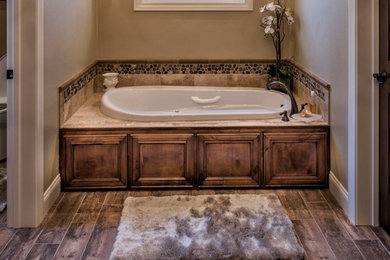 Mid-sized elegant master multicolored tile and pebble tile porcelain tile and brown floor drop-in bathtub photo in Other with brown walls