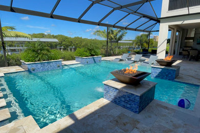 Diseño de piscina alargada costera grande rectangular en patio trasero con adoquines de piedra natural