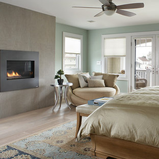Réalisation d'une grande chambre parentale tradition avec un mur bleu, un manteau de cheminée en béton et une cheminée standard.