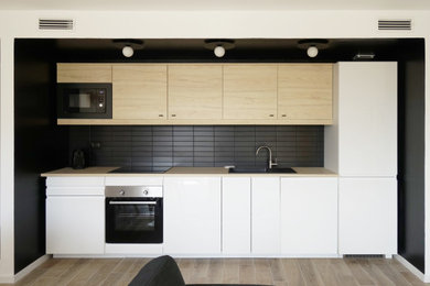 Réalisation d'une cuisine noire et bois design avec un plan de travail en bois, une crédence noire et un plan de travail beige.