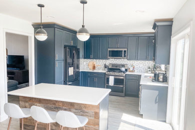Mid-sized cottage u-shaped vinyl floor and brown floor eat-in kitchen photo in Chicago with an undermount sink, shaker cabinets, gray cabinets, quartz countertops, gray backsplash, porcelain backsplash, stainless steel appliances, an island and white countertops