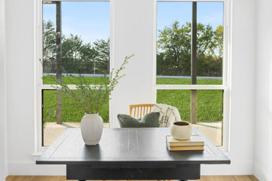 Diseño de despacho minimalista de tamaño medio con suelo de madera en tonos medios y suelo marrón