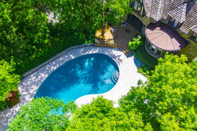 Large elegant backyard stone and kidney-shaped pool landscaping photo in Toronto