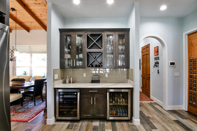 Example of a mid-sized transitional single-wall porcelain tile and brown floor home bar design in Miami with no sink, glass-front cabinets, dark wood cabinets, quartzite countertops, beige backsplash, subway tile backsplash and white countertops