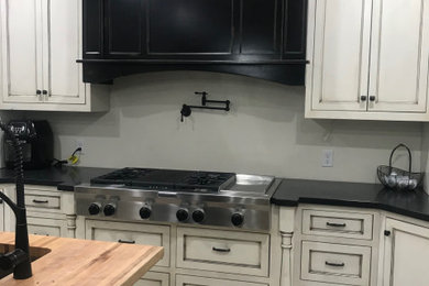 Antique white cabinets with black distressed island