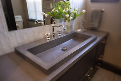 Small trendy white tile and subway tile ceramic tile, gray floor and single-sink walk-in shower photo in Other with flat-panel cabinets, black cabinets, a one-piece toilet, white walls, a trough sink, a hinged shower door, gray countertops and a built-in vanity