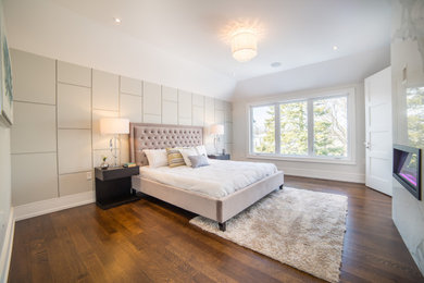 Bedroom - mid-sized transitional master medium tone wood floor, brown floor and tray ceiling bedroom idea in Toronto with white walls, a standard fireplace and a stone fireplace