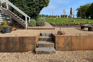 Design ideas for a mid-sized and australian native country garden in Geelong with a fire feature, a garden path, with raised garden bed, a retaining wall and with rock feature.
