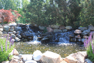 Photo of a large traditional partial sun backyard stone landscaping in Omaha for spring.