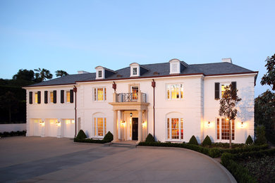 Large traditional white three-story brick exterior home idea in Los Angeles with a clipped gable roof