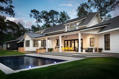 Inspiration for a large cottage white two-story wood house exterior remodel in New Orleans with a clipped gable roof and a shingle roof
