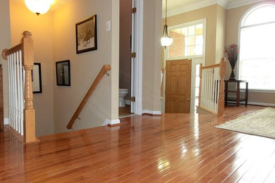 Entryway - mid-sized transitional medium tone wood floor entryway idea in DC Metro with beige walls and a light wood front door