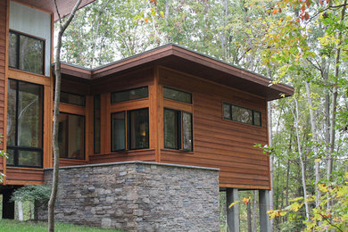Photo of a contemporary one-storey house exterior in Richmond with wood siding and a shed roof.