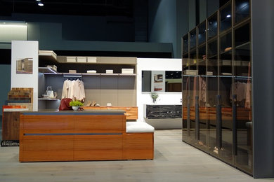 Imagen de armario vestidor minimalista grande con armarios abiertos y suelo de madera clara