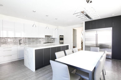 Inspiration for a large modern l-shaped eat-in kitchen in New York with an undermount sink, flat-panel cabinets, white cabinets, granite benchtops, grey splashback, glass tile splashback, stainless steel appliances, ceramic floors, with island, multi-coloured floor and white benchtop.