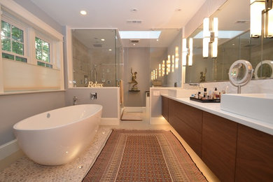 Bathroom - large contemporary master stone slab pebble tile floor and beige floor bathroom idea in DC Metro with flat-panel cabinets, medium tone wood cabinets, quartz countertops, gray walls, a pedestal sink and a hinged shower door