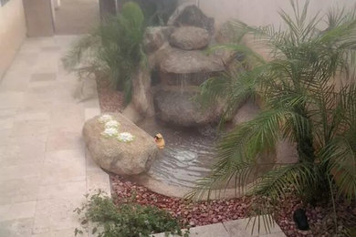 Photo of a mid-sized side yard stone water fountain landscape in Phoenix.
