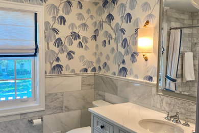 Design ideas for a medium sized classic ensuite bathroom in Chicago with raised-panel cabinets, grey cabinets, an alcove bath, a shower/bath combination, a one-piece toilet, grey tiles, marble tiles, blue walls, marble flooring, a submerged sink, quartz worktops, grey floors, a shower curtain, white worktops, a single sink, a built in vanity unit, a wallpapered ceiling and wallpapered walls.